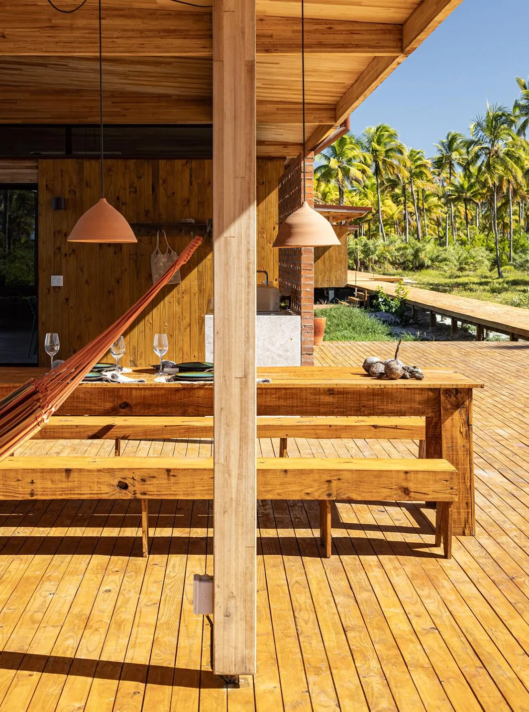 Varanda em madeira da Casa Modular com rede e pendentes